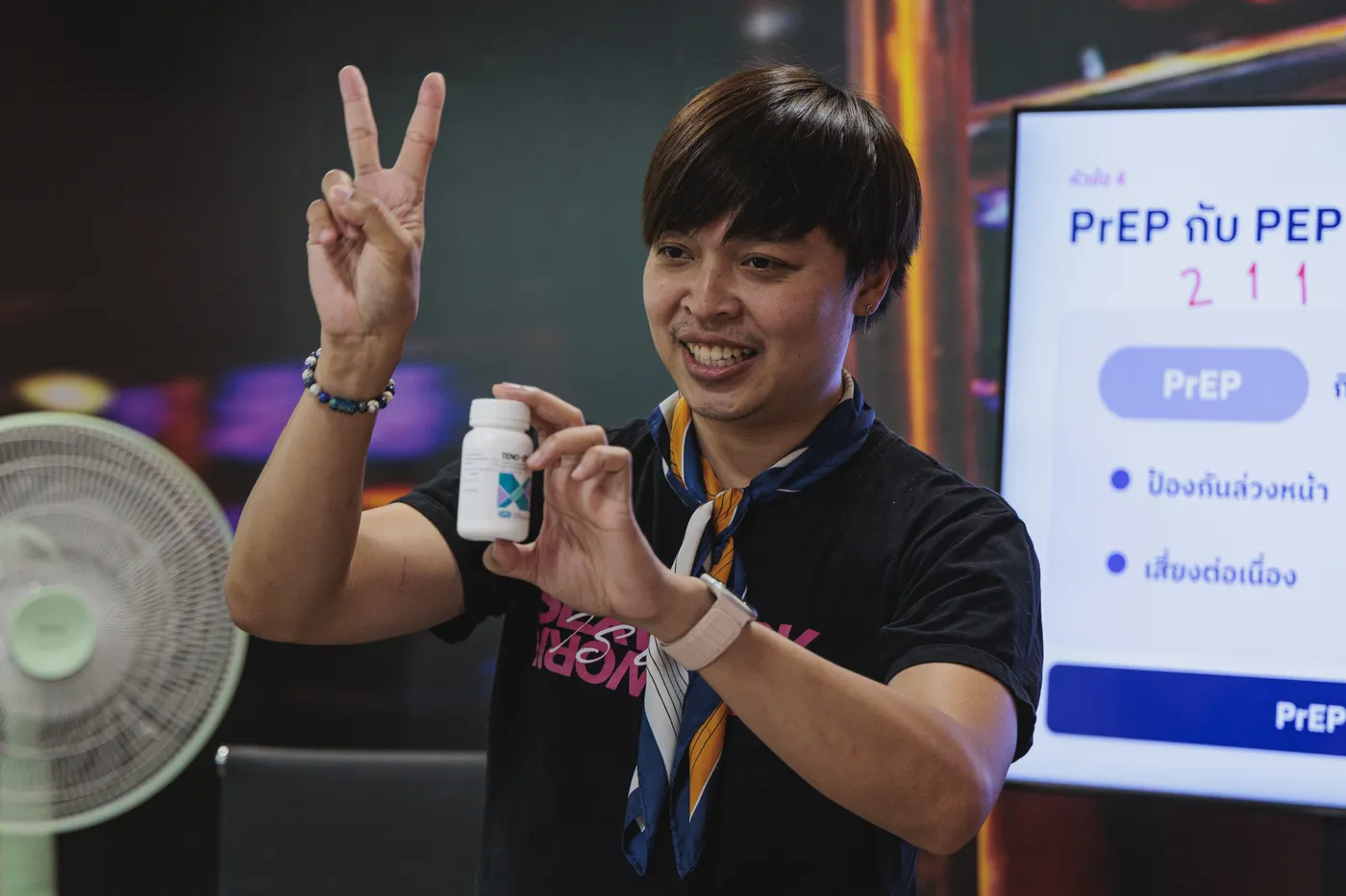 Arm holding a bottle of PrEP pills and making a peace sign at the SWING clinic